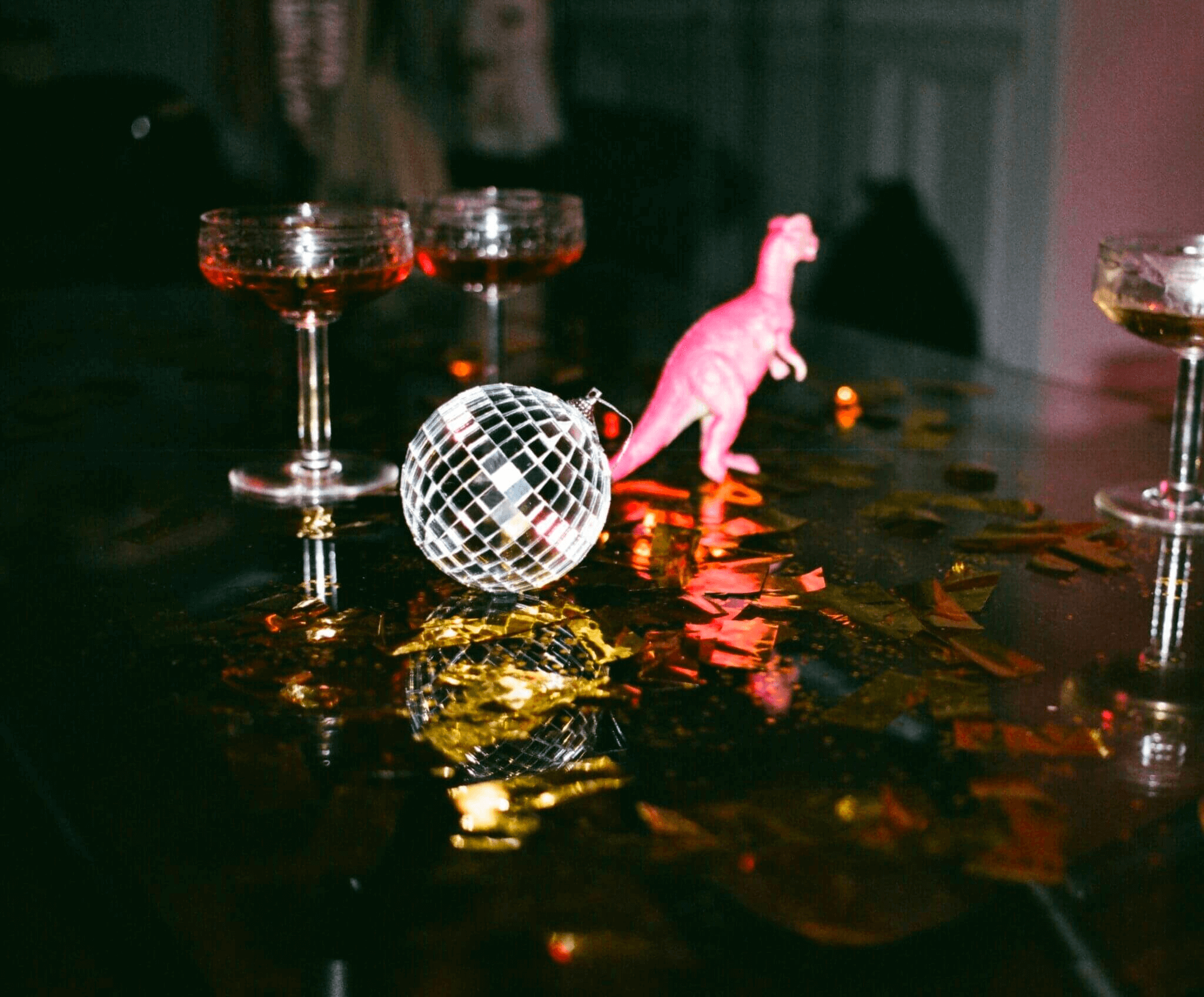 DJ Hochzeit Hochzeits-DJ Ein Glas Wein auf einem Tisch neben einer rosa Dinosaurierfigur, aufgestellt bei einer DJ-Hochzeit in Düsseldorf.